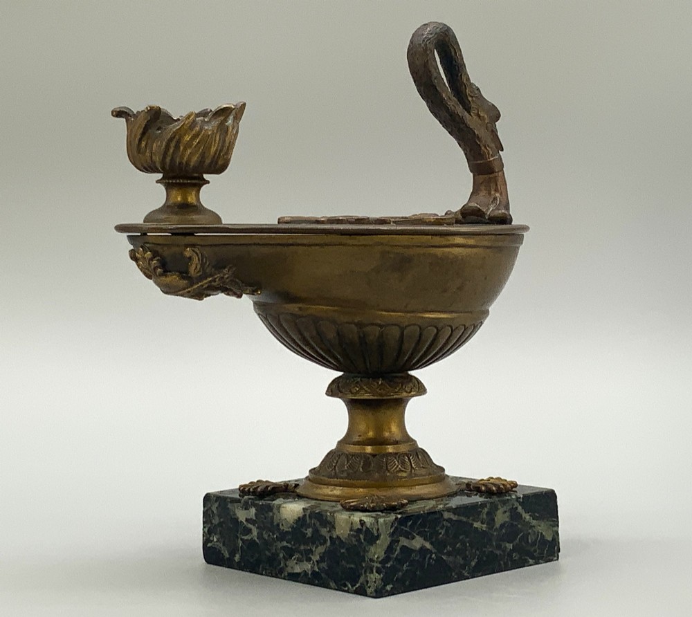 A nineteenth-century Grand Tour patinated bronze oil lamp featuring a serpent handle and gadrooned body, mounted on a square green marble base. View X