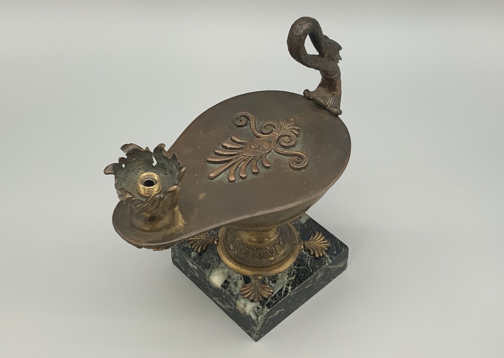 A nineteenth-century Grand Tour patinated bronze oil lamp featuring a serpent handle and gadrooned body, mounted on a square green marble base. View XII