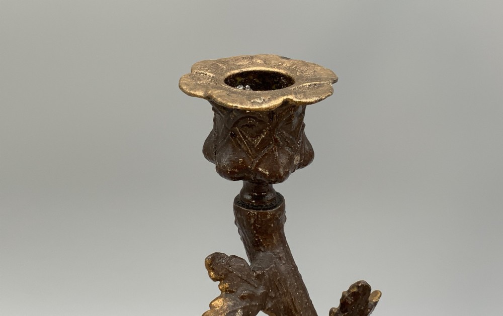 A pair of 19th-century gilded and patinated bronze candlesticks featuring detailed figures of hunting dogs at the base beneath tree-branch shafts. View XII