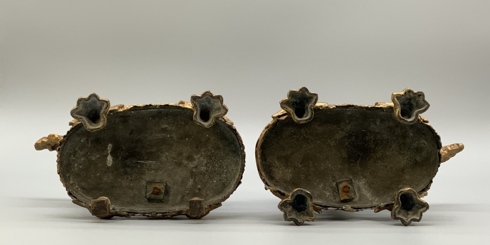 A pair of 19th-century gilded and patinated bronze candlesticks featuring detailed figures of hunting dogs at the base beneath tree-branch shafts. View XIII