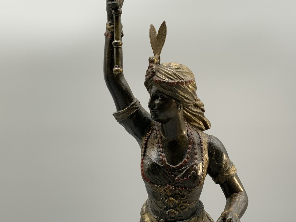 A pair of 19th-century polychrome spelter figural candlesticks depicting male and female torchbearer figures raised on carved wooden bases. View VI