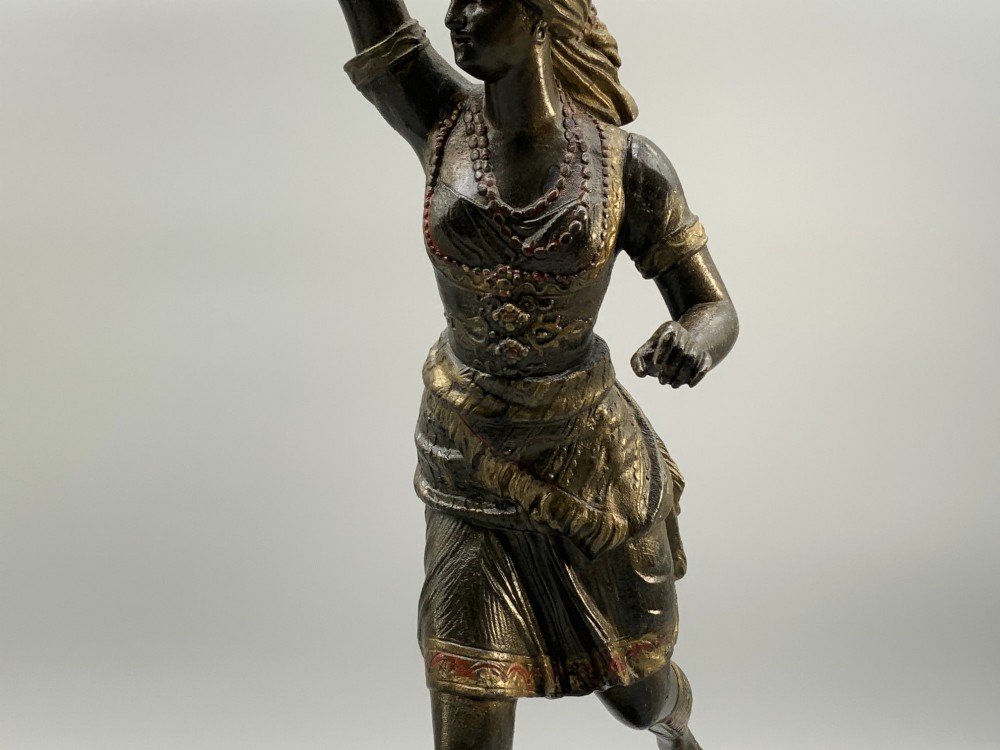 A pair of 19th-century polychrome spelter figural candlesticks depicting male and female torchbearer figures raised on carved wooden bases. View VII