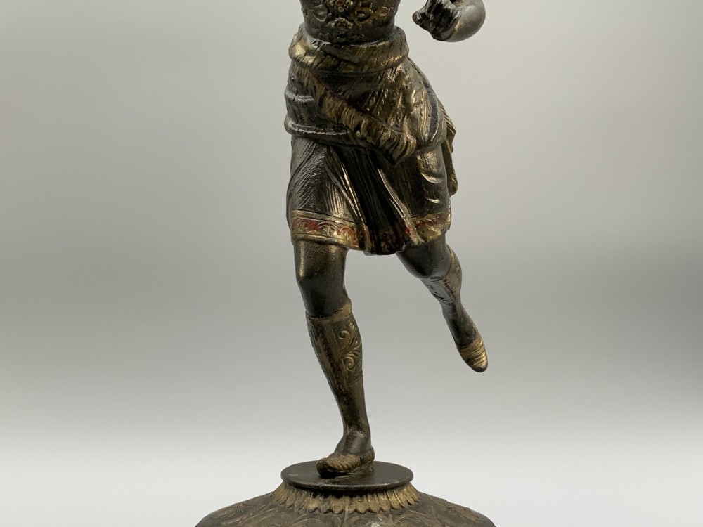 A pair of 19th-century polychrome spelter figural candlesticks depicting male and female torchbearer figures raised on carved wooden bases. View VIII