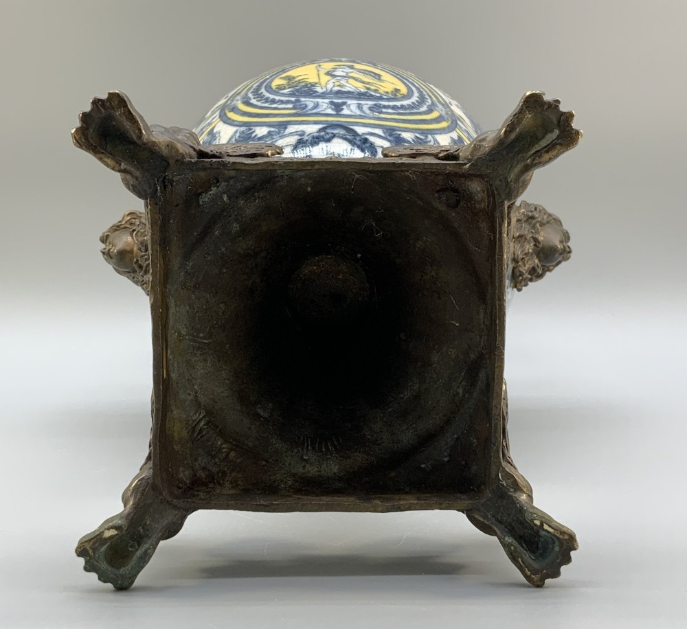 A Renaissance Revival faience vase featuring blue and yellow glazed classical medallion artwork mounted on a cast bronze footed base with mask handles. View XV