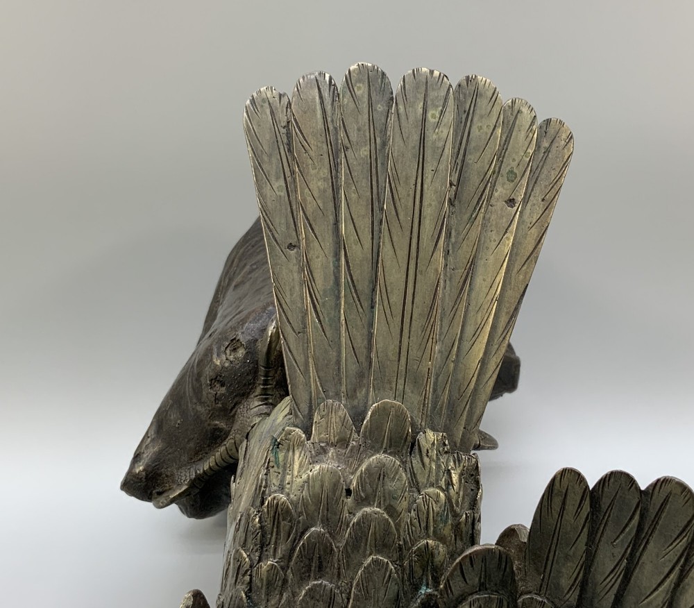 A dark bronze sculpture depicting an eagle with outstretched wings perched on a rocky base. View XIV