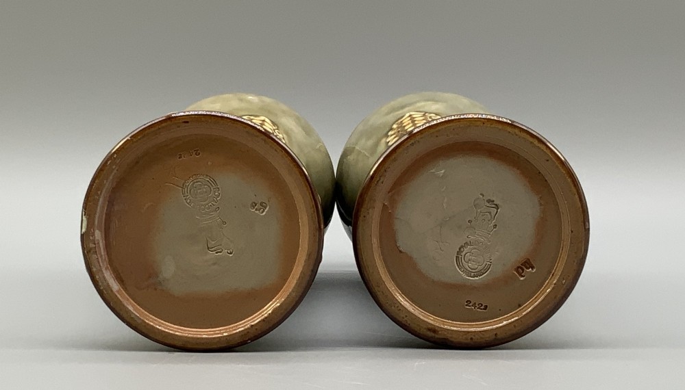A matched pair of Royal Doulton Lambeth Art Nouveau stoneware vases featuring raised relief botanical motifs on a muted olive green glazed ground. View IX