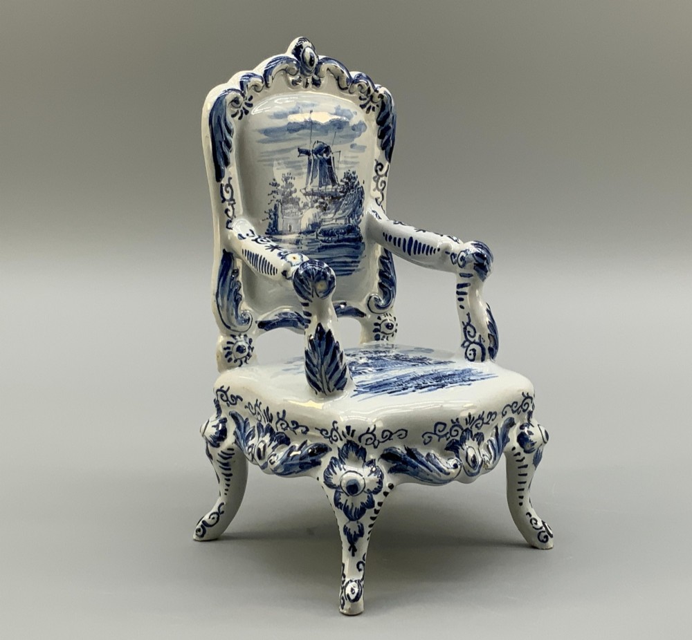 A late 19th-century miniature porcelain armchair glazed in white and hand-painted with blue Dutch landscape scenes featuring a windmill.