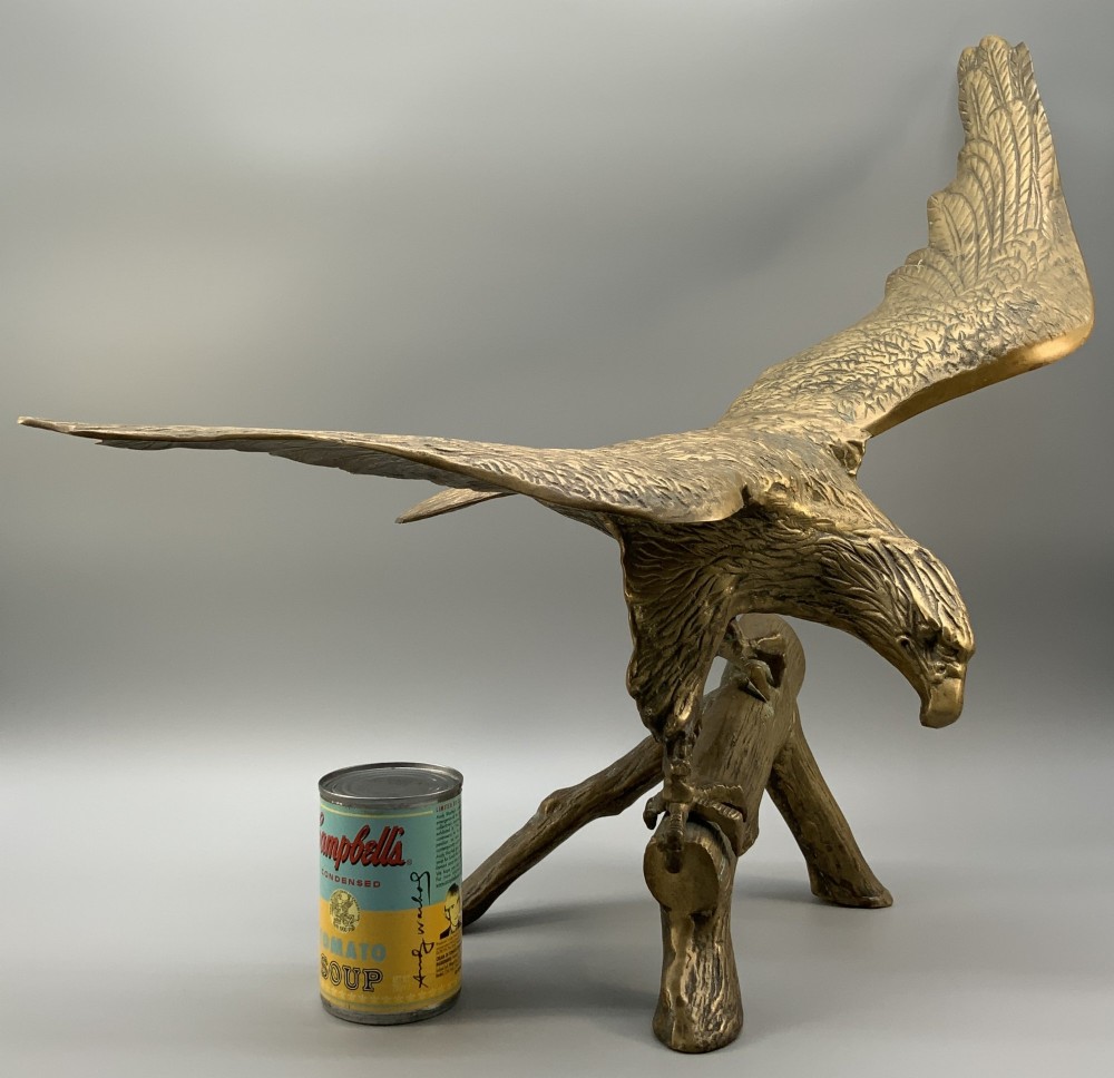 A cast brass sculpture depicting an eagle with outstretched wings perched atop a detailed log branch. View III