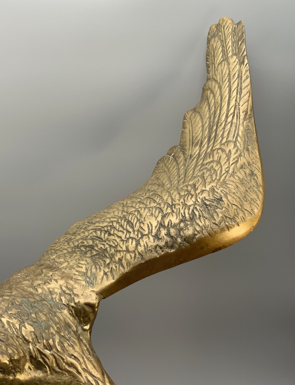 A cast brass sculpture depicting an eagle with outstretched wings perched atop a detailed log branch. View V