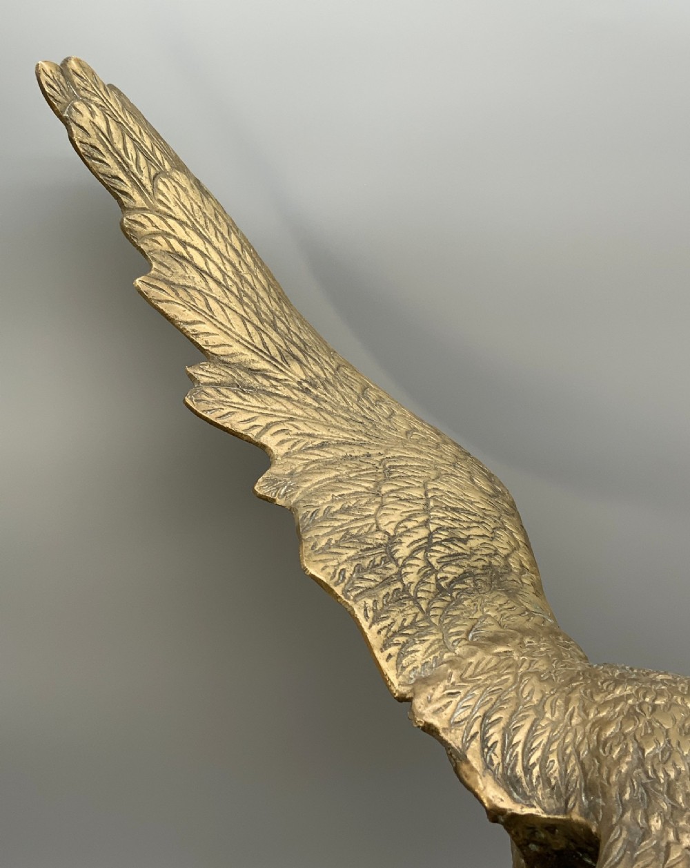 A cast brass sculpture depicting an eagle with outstretched wings perched atop a detailed log branch. View XIII