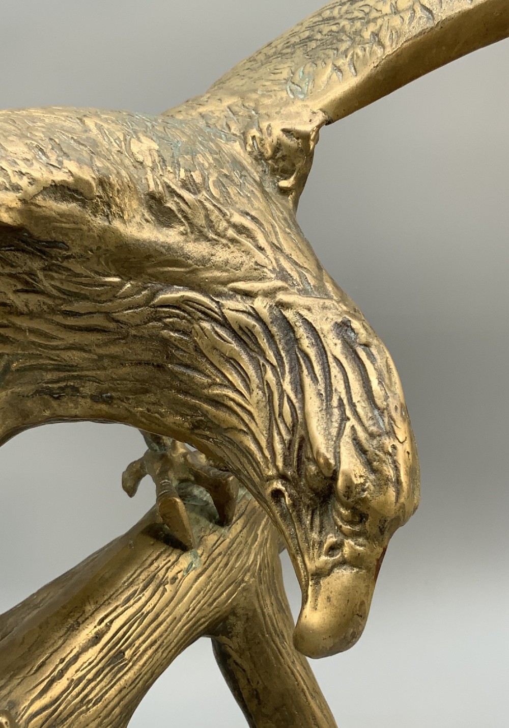 A cast brass sculpture depicting an eagle with outstretched wings perched atop a detailed log branch. View XIV