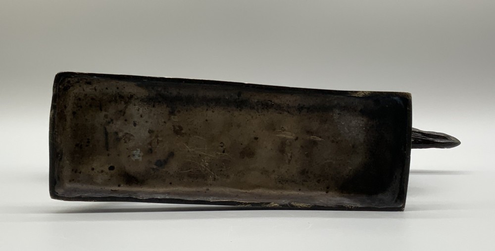 A patinated bronze sculpture depicting a racehorse and jockey mid-stride set upon a textured rectangular bronze base. View XV