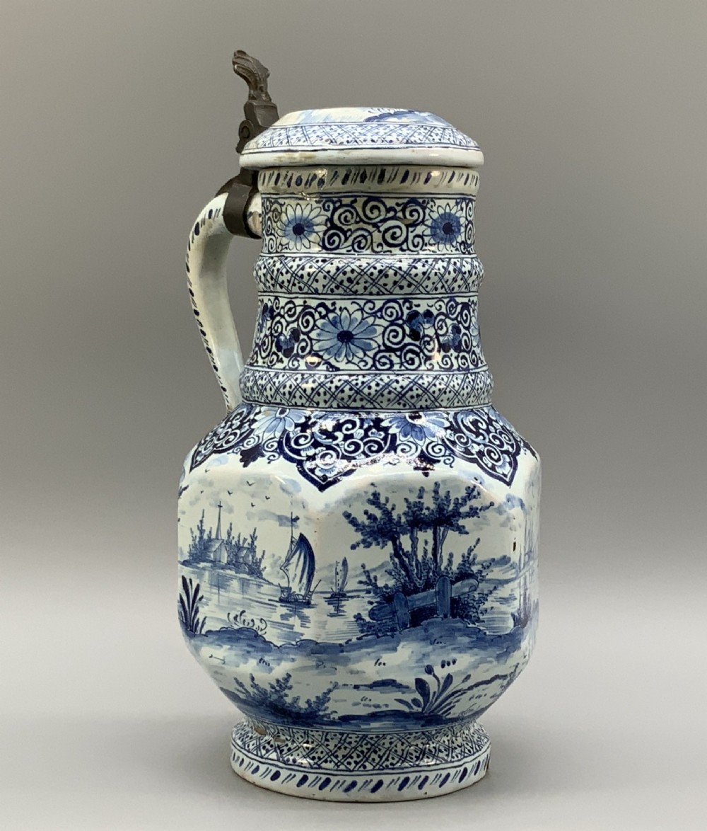 An eighteenth-century blue and white Dutch Delftware ceramic jug decorated with hand-painted figures, complete with a fitted pewter lid. View VI
