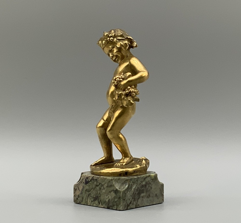 A small gilt bronze sculpture depicting an infant Bacchus holding a bunch of grapes, set upon a square green marble plinth. View IV