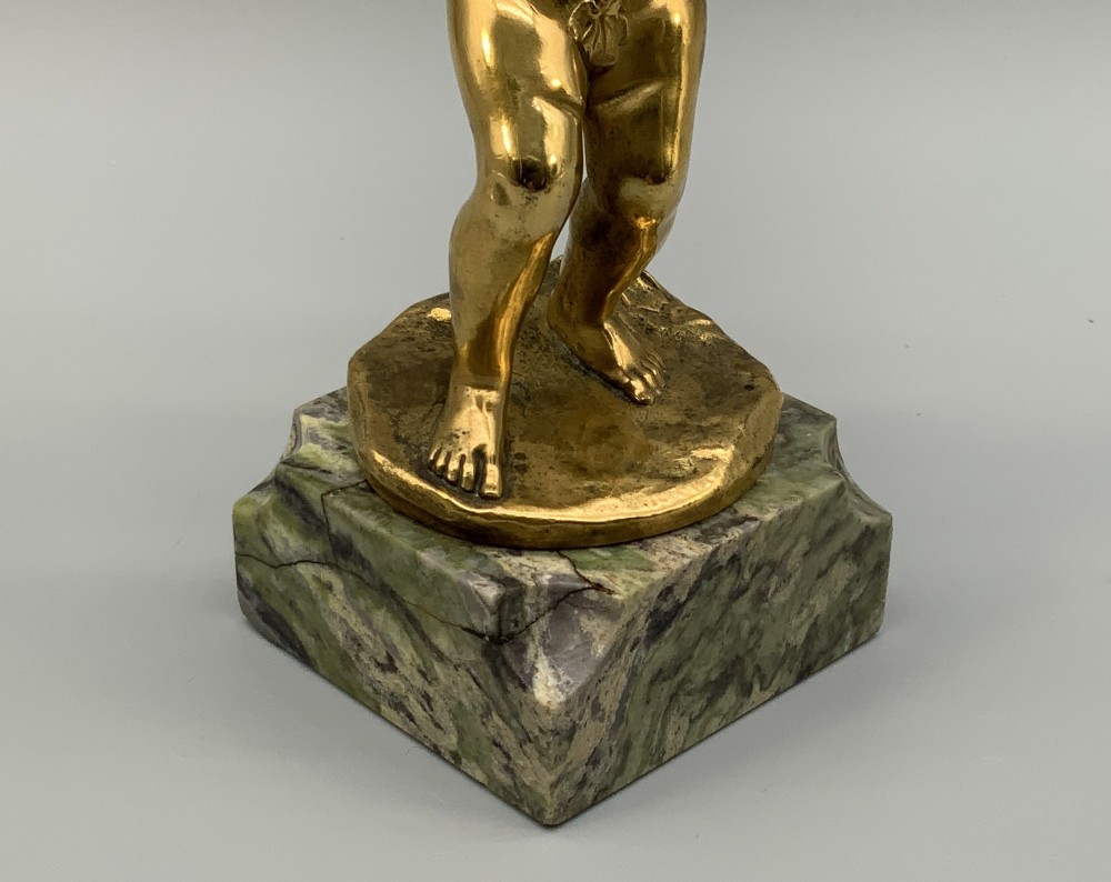 A small gilt bronze sculpture depicting an infant Bacchus holding a bunch of grapes, set upon a square green marble plinth. View XI