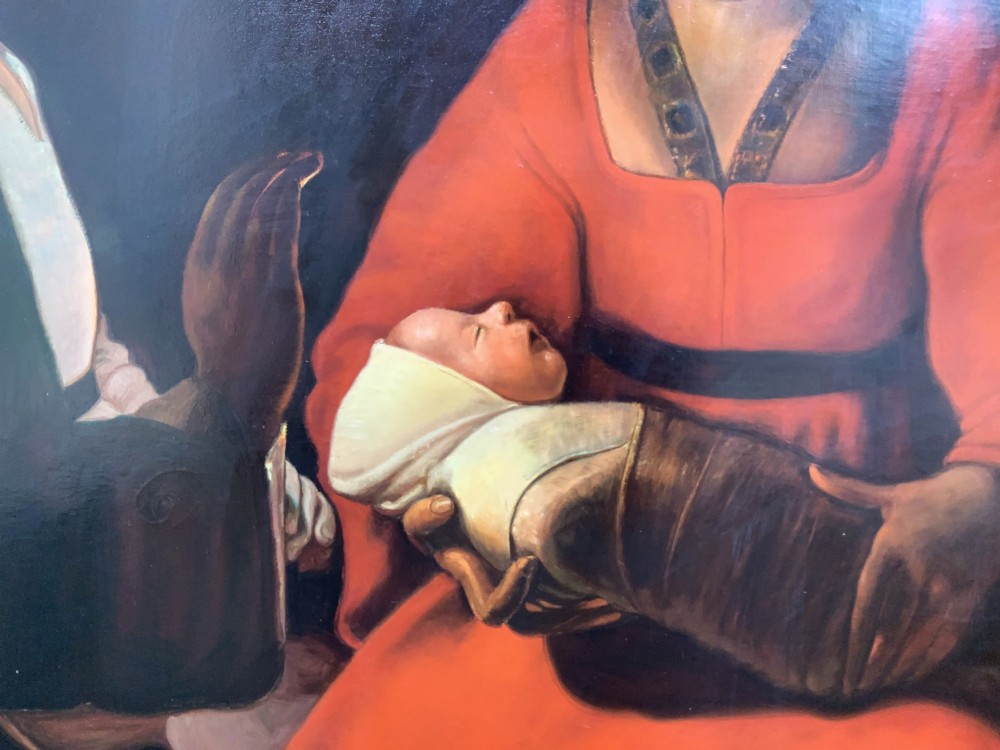 A framed twentieth-century oil painting depicting two women in dramatic candlelight illumination leaning over a swaddled infant inside an ornate gold frame. View X