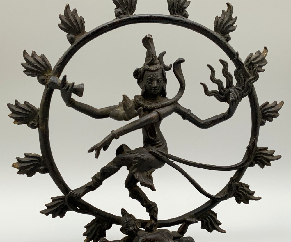 A dark patinated bronze 19th-century figure of Shiva Nataraja dancing within a circular halo of flames atop a lotus pedestal. View IV