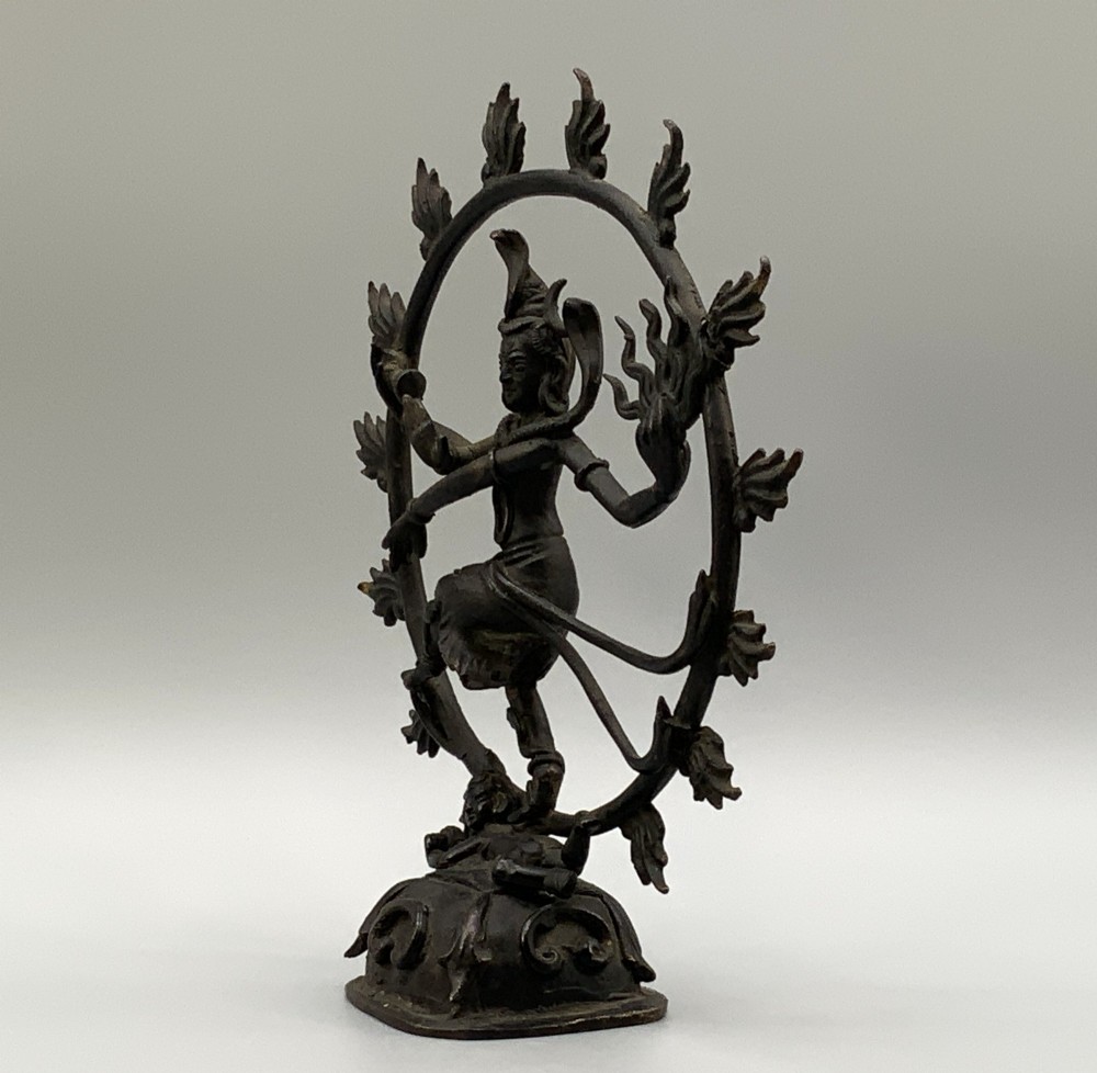 A dark patinated bronze 19th-century figure of Shiva Nataraja dancing within a circular halo of flames atop a lotus pedestal. View VII