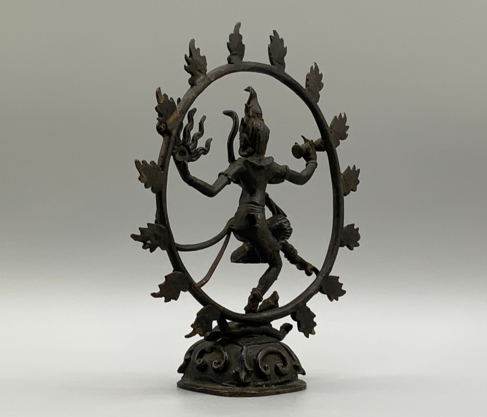 A dark patinated bronze 19th-century figure of Shiva Nataraja dancing within a circular halo of flames atop a lotus pedestal. View IX