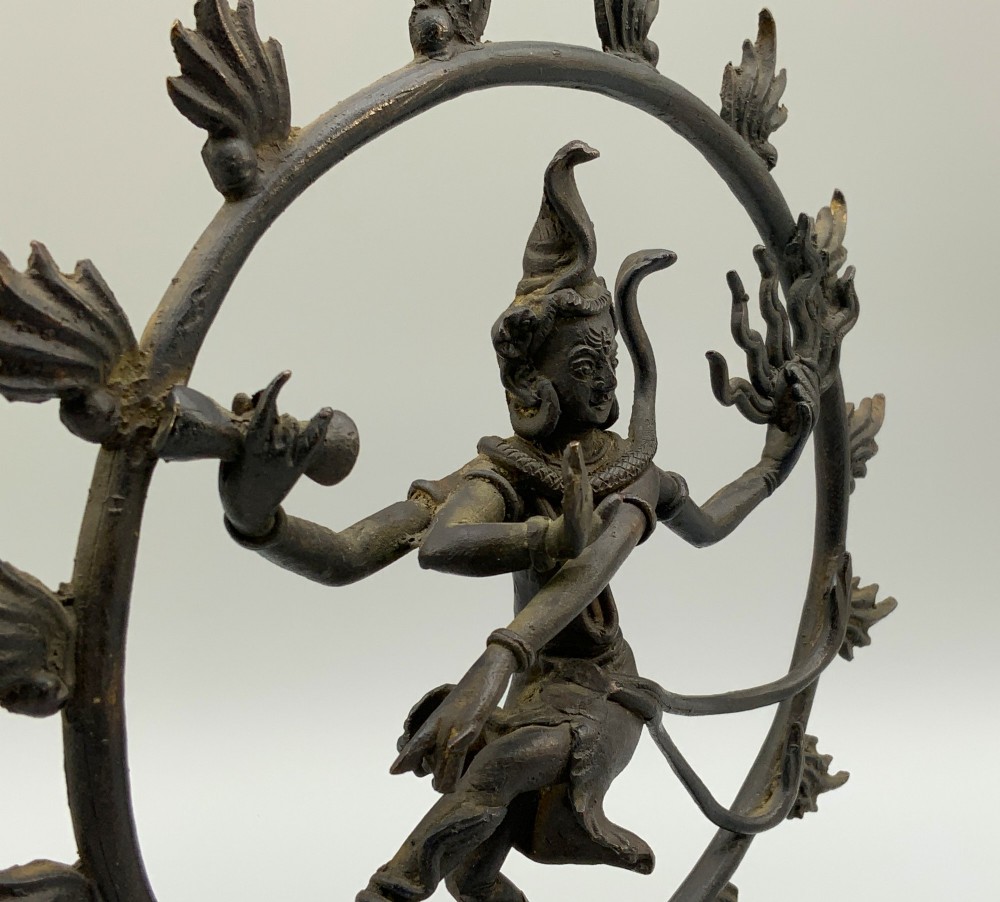 A dark patinated bronze 19th-century figure of Shiva Nataraja dancing within a circular halo of flames atop a lotus pedestal. View XI