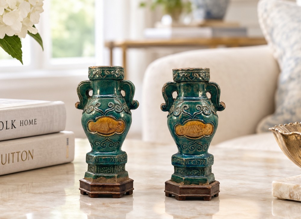 A pair of early seventeenth-century Chinese ceramic vases featuring turquoise glaze, amber reserves, relief scrollwork, and wooden bases. View II