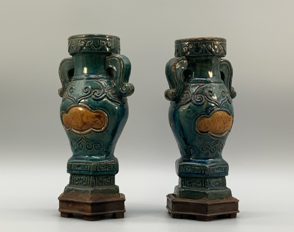 A pair of early seventeenth-century Chinese ceramic vases featuring turquoise glaze, amber reserves, relief scrollwork, and wooden bases. View IV