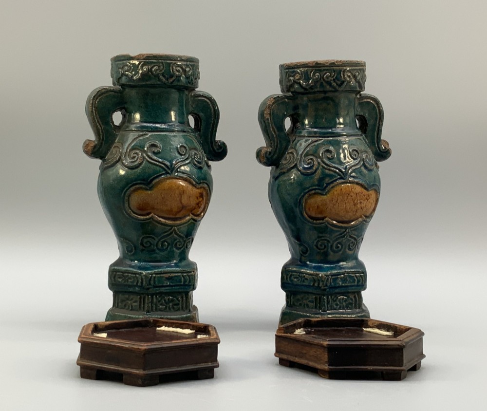 A pair of early seventeenth-century Chinese ceramic vases featuring turquoise glaze, amber reserves, relief scrollwork, and wooden bases. View IX
