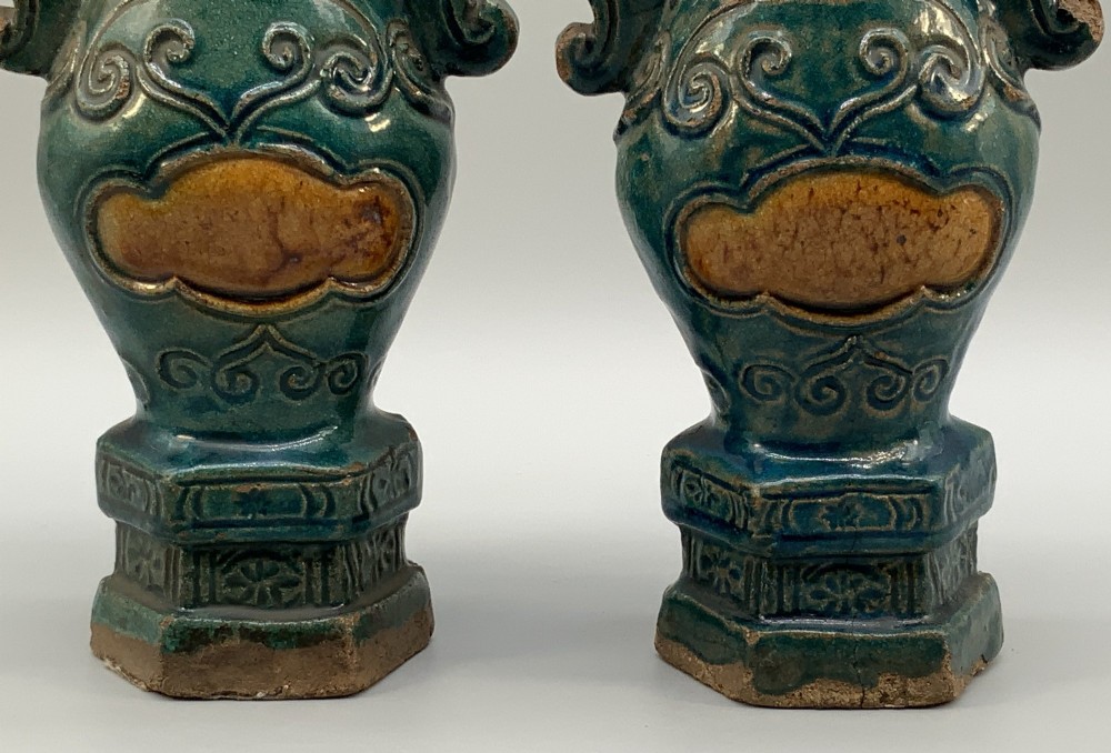 A pair of early seventeenth-century Chinese ceramic vases featuring turquoise glaze, amber reserves, relief scrollwork, and wooden bases. View XI