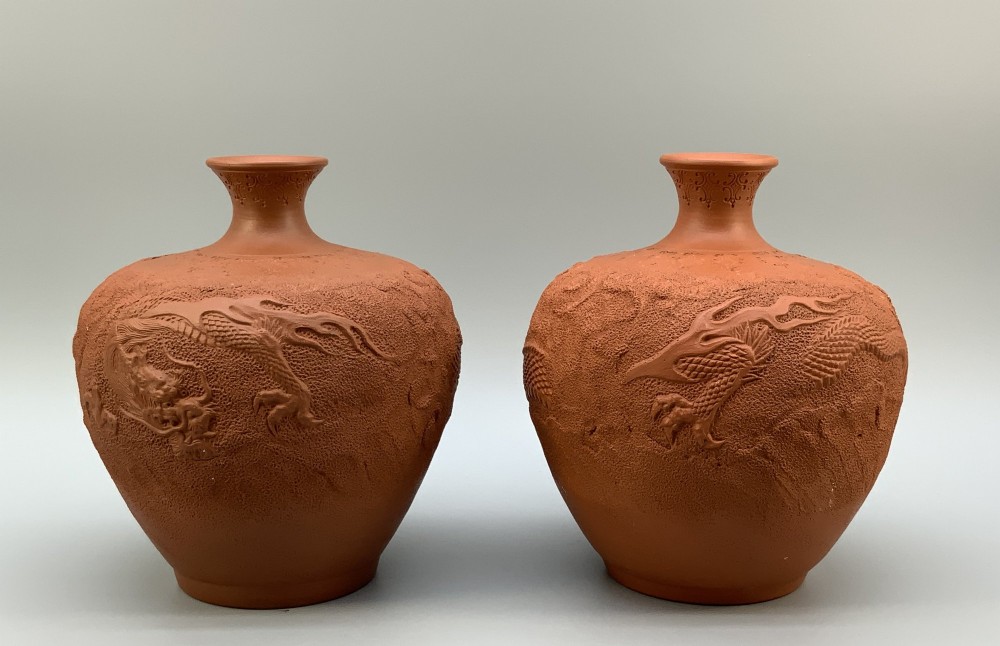 A pair of unglazed terracotta red clay vases featuring detailed relief carvings of dragons with narrow flared necks. View IV