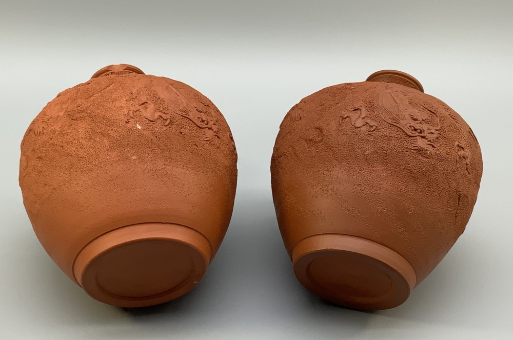 A pair of unglazed terracotta red clay vases featuring detailed relief carvings of dragons with narrow flared necks. View XI