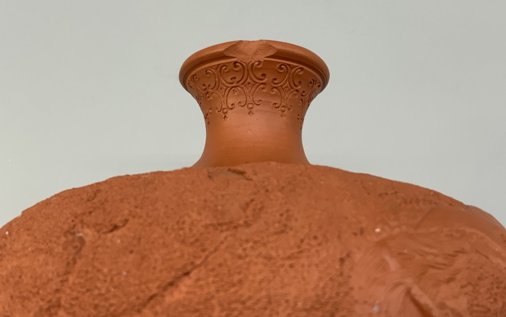A pair of unglazed terracotta red clay vases featuring detailed relief carvings of dragons with narrow flared necks. View XII