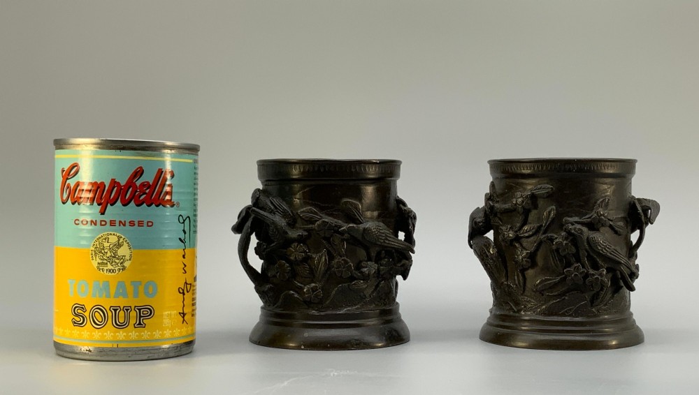 A pair of cylindrical dark patinated bronze vases featuring raised relief depictions of birds perched amongst cherry blossom branches. View III