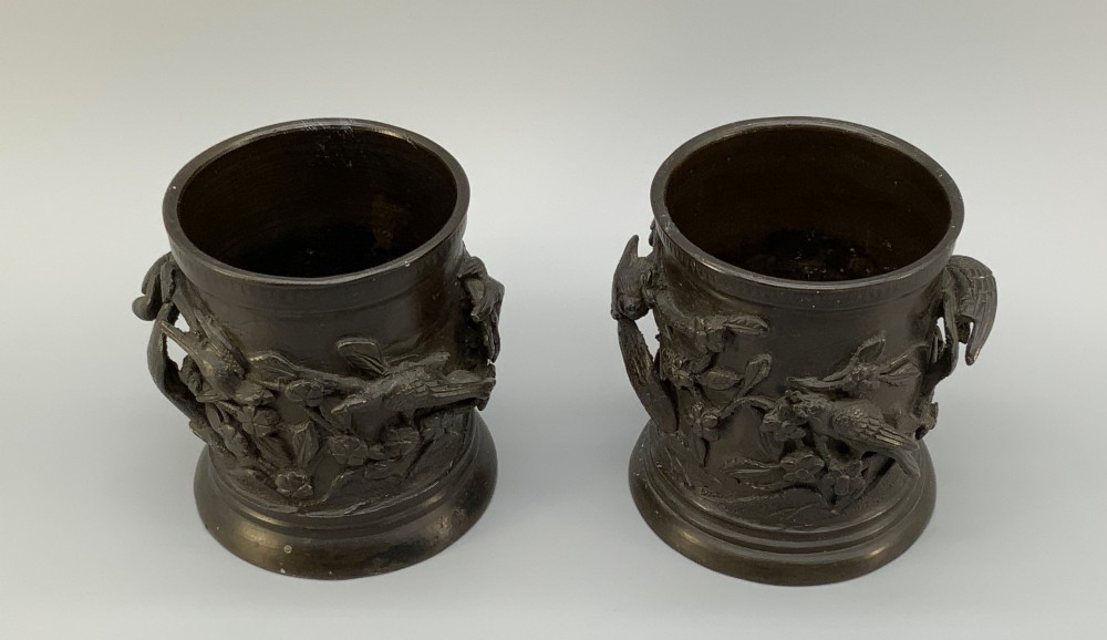 A pair of cylindrical dark patinated bronze vases featuring raised relief depictions of birds perched amongst cherry blossom branches. View IV