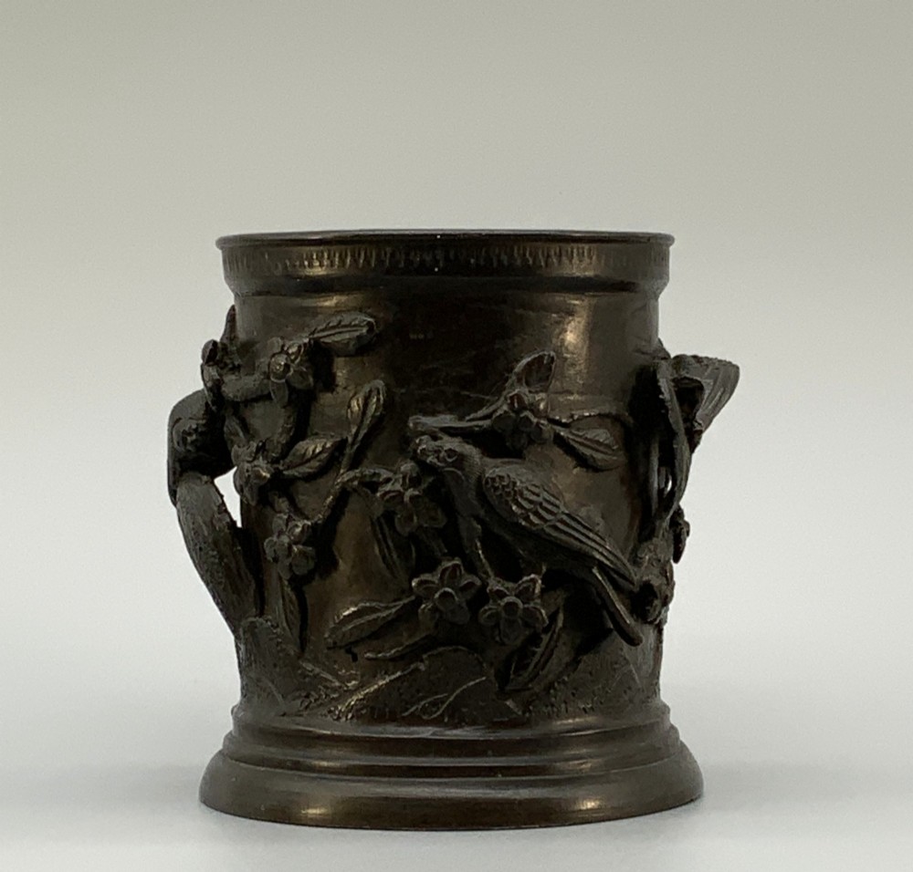 A pair of cylindrical dark patinated bronze vases featuring raised relief depictions of birds perched amongst cherry blossom branches. View V