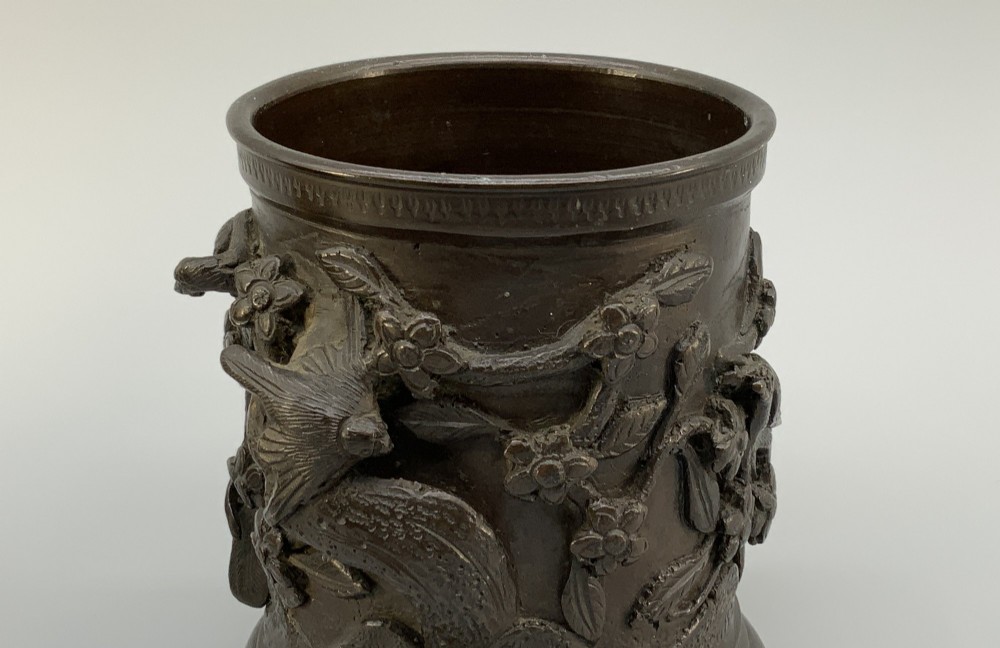 A pair of cylindrical dark patinated bronze vases featuring raised relief depictions of birds perched amongst cherry blossom branches. View VII
