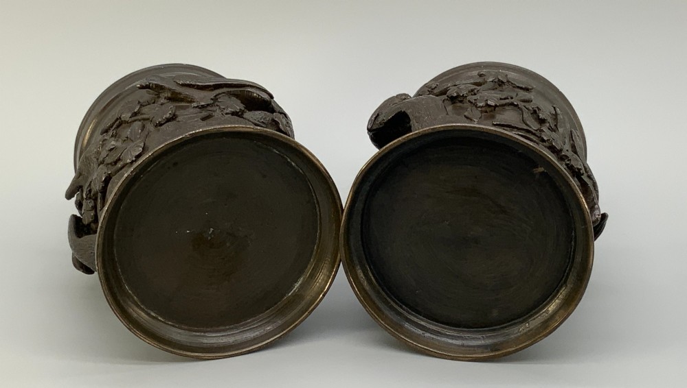 A pair of cylindrical dark patinated bronze vases featuring raised relief depictions of birds perched amongst cherry blossom branches. View X