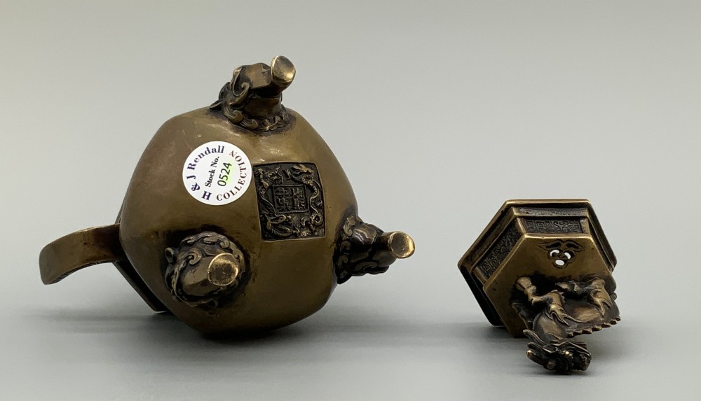 A late Qing dynasty hexagonal bronze tripod censer featuring upright side handles, a removable cover topped with a mythical beast finial, and feet shaped as animal masks. View XI