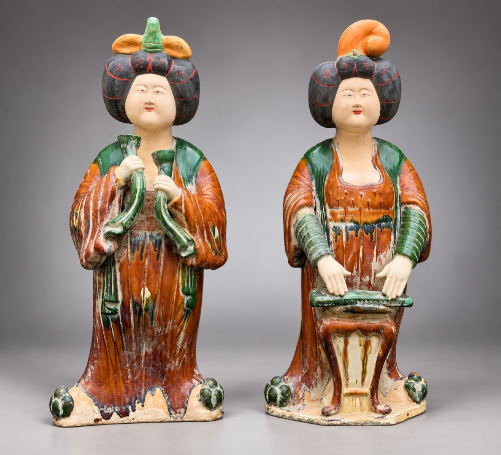 A pair of standing terracotta female musician figures in Tang Dynasty style, finished with amber, green, and cream Sancai lead glazes.
