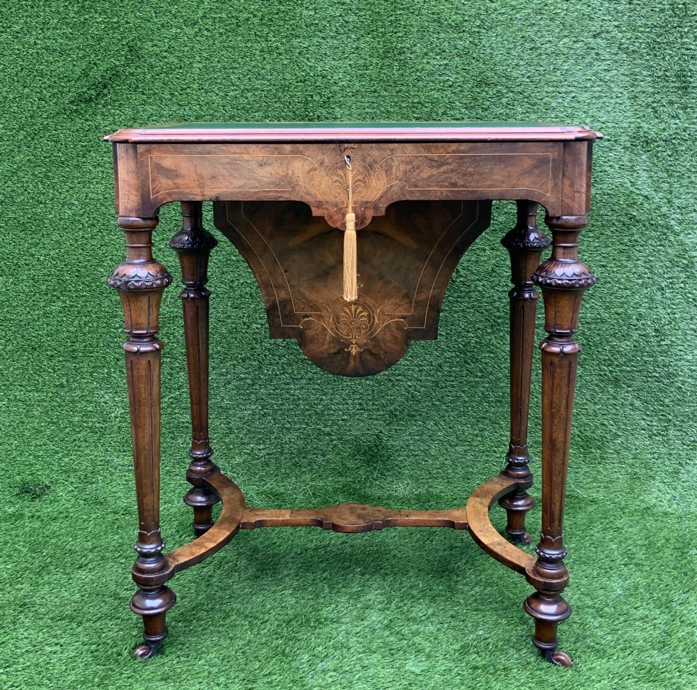 A 19th-century burr walnut work table featuring a green leather inset top, floral marquetry inlay, turned legs, and a hanging storage pouch. View II