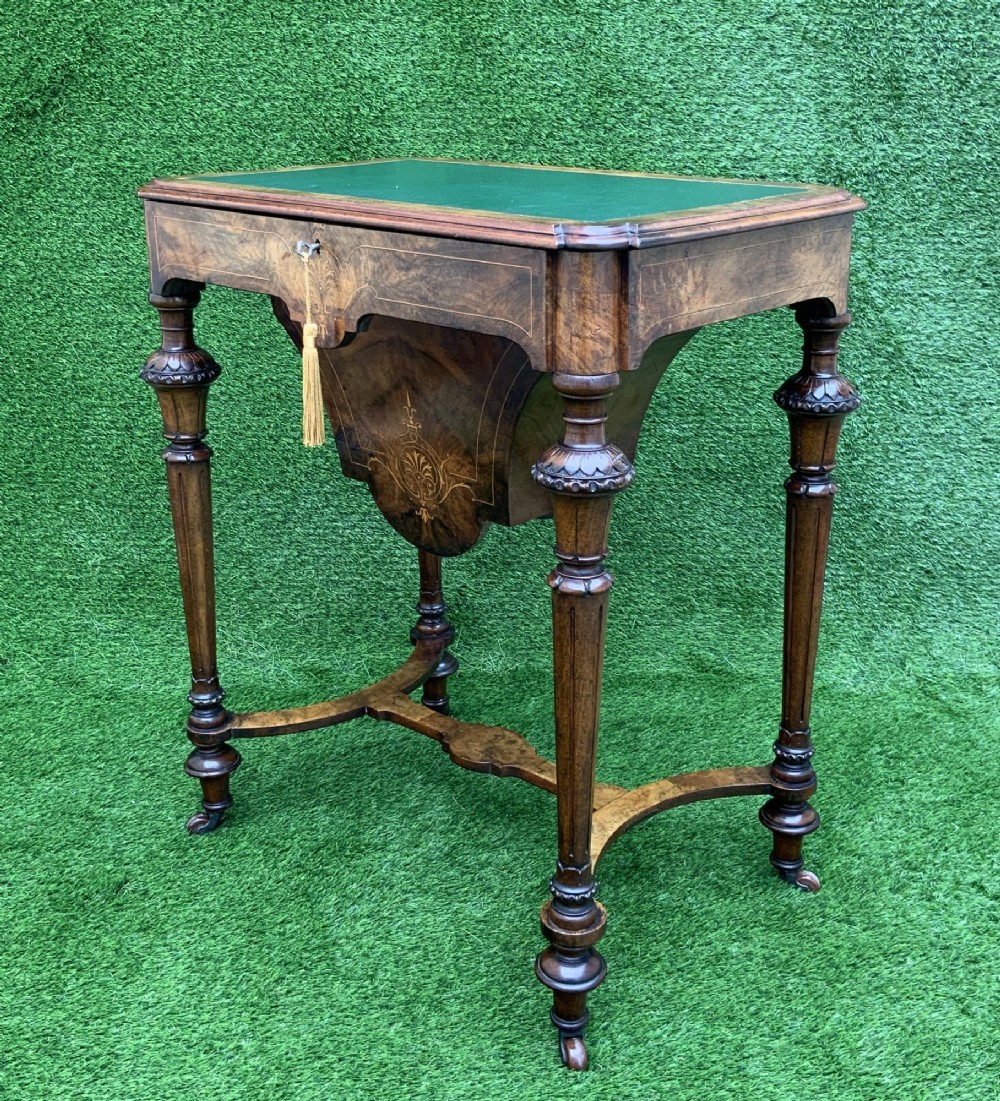 A 19th-century burr walnut work table featuring a green leather inset top, floral marquetry inlay, turned legs, and a hanging storage pouch. View III