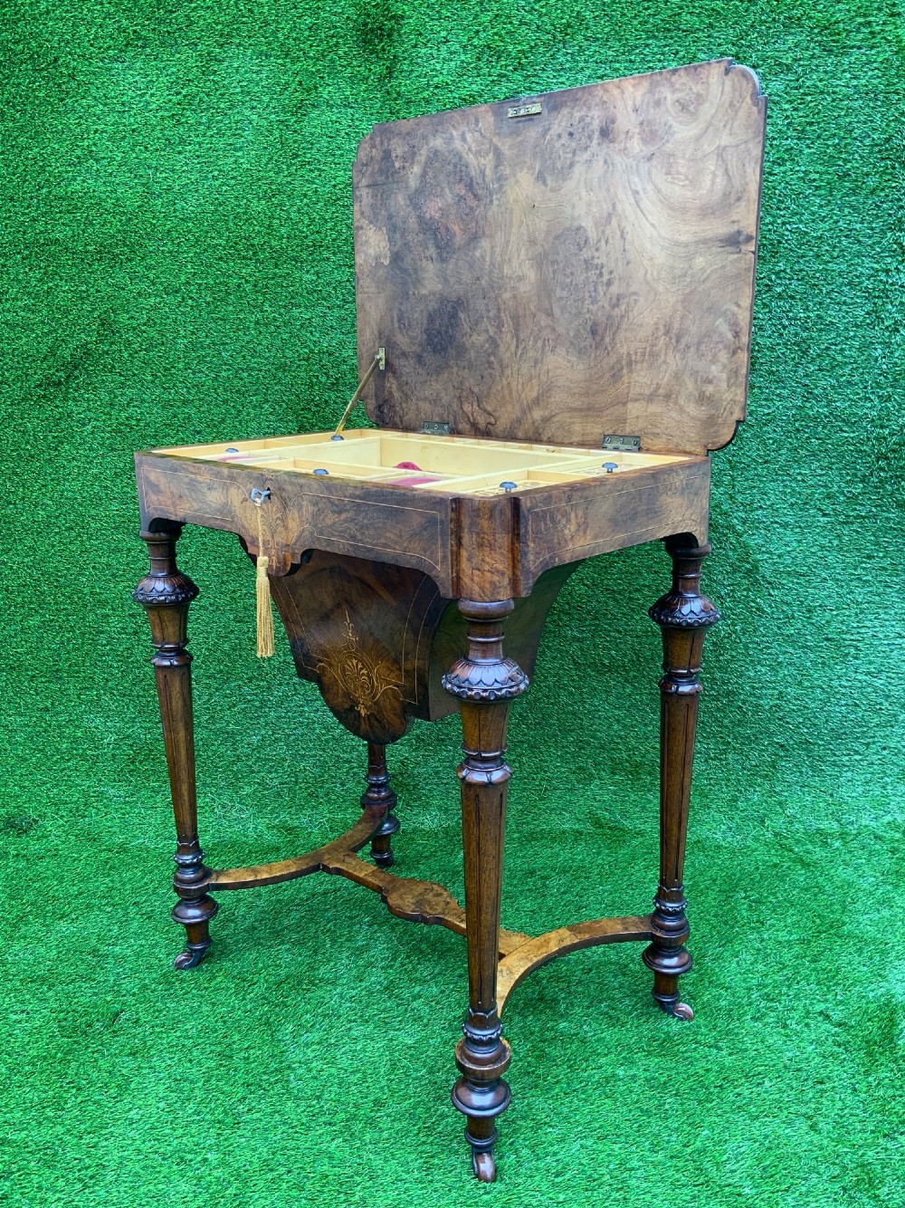 A 19th-century burr walnut work table featuring a green leather inset top, floral marquetry inlay, turned legs, and a hanging storage pouch. View IV