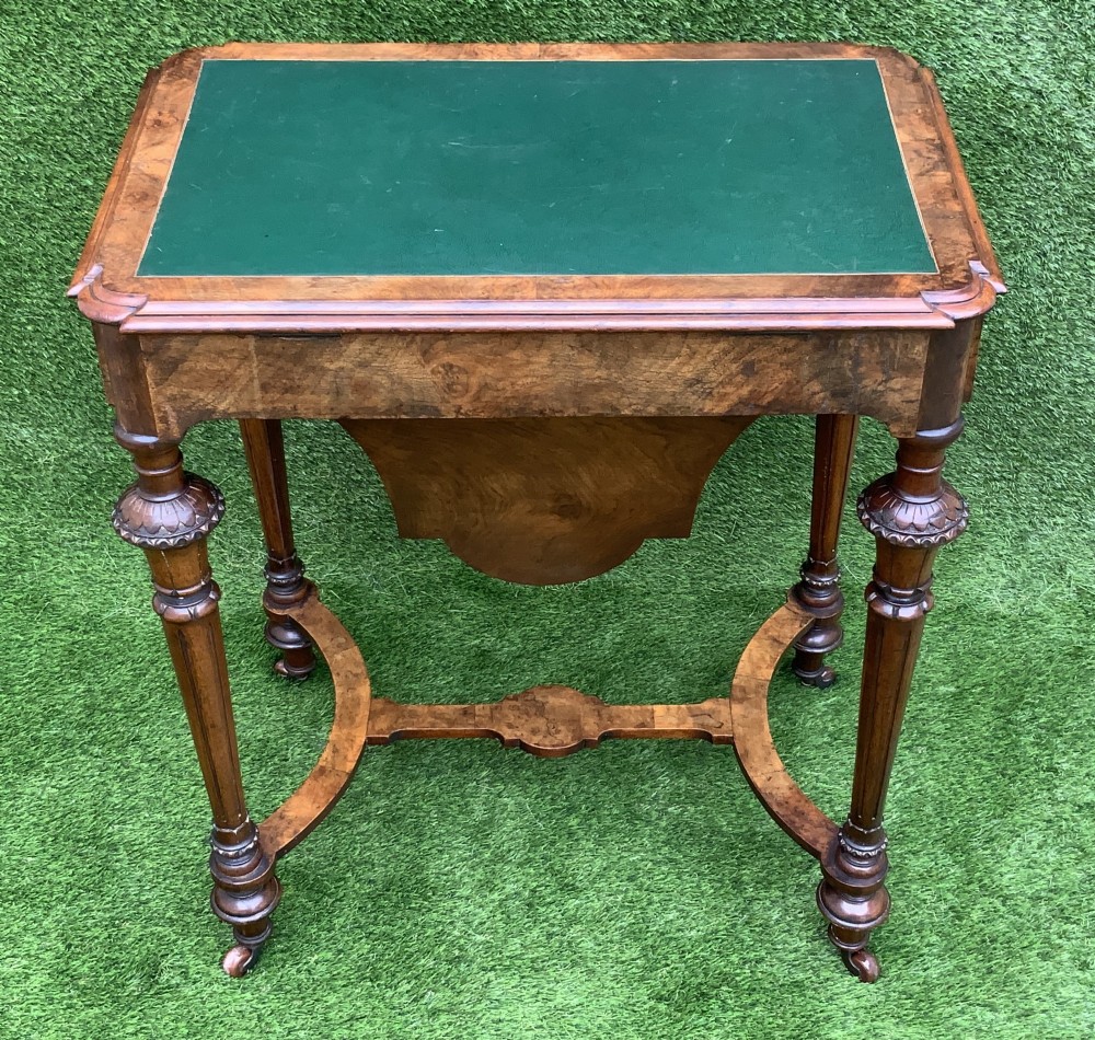 A 19th-century burr walnut work table featuring a green leather inset top, floral marquetry inlay, turned legs, and a hanging storage pouch. View XII