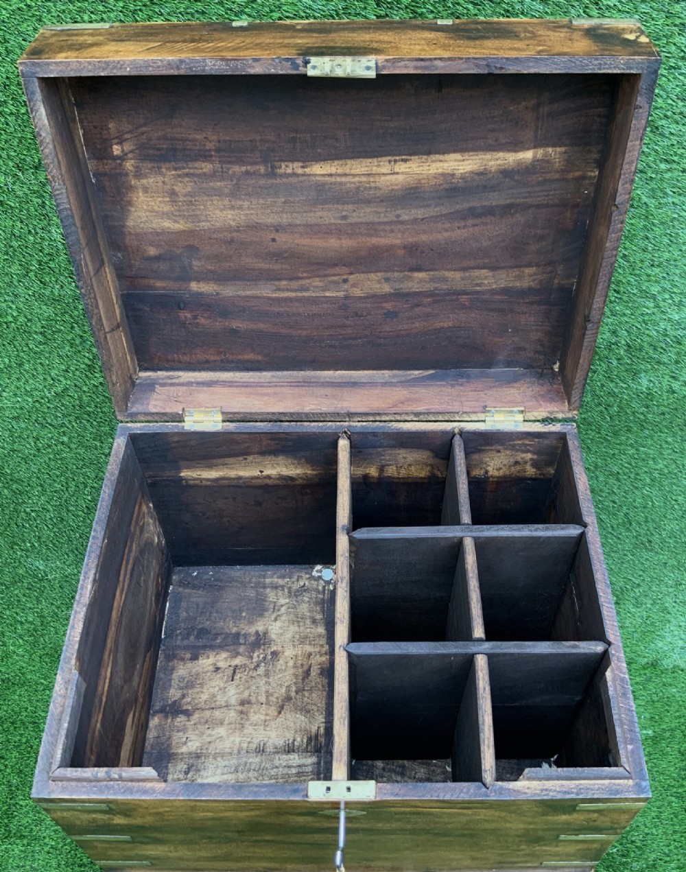 A dark teak Anglo-Indian wine cellarette box with brass corner mounts resting on a carved turned-leg wooden stand. View VI