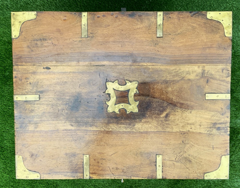 A dark teak Anglo-Indian wine cellarette box with brass corner mounts resting on a carved turned-leg wooden stand. View X