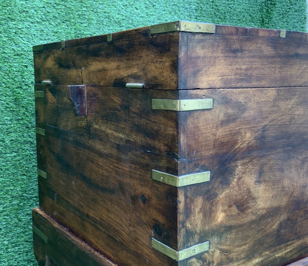 A dark teak Anglo-Indian wine cellarette box with brass corner mounts resting on a carved turned-leg wooden stand. View XI