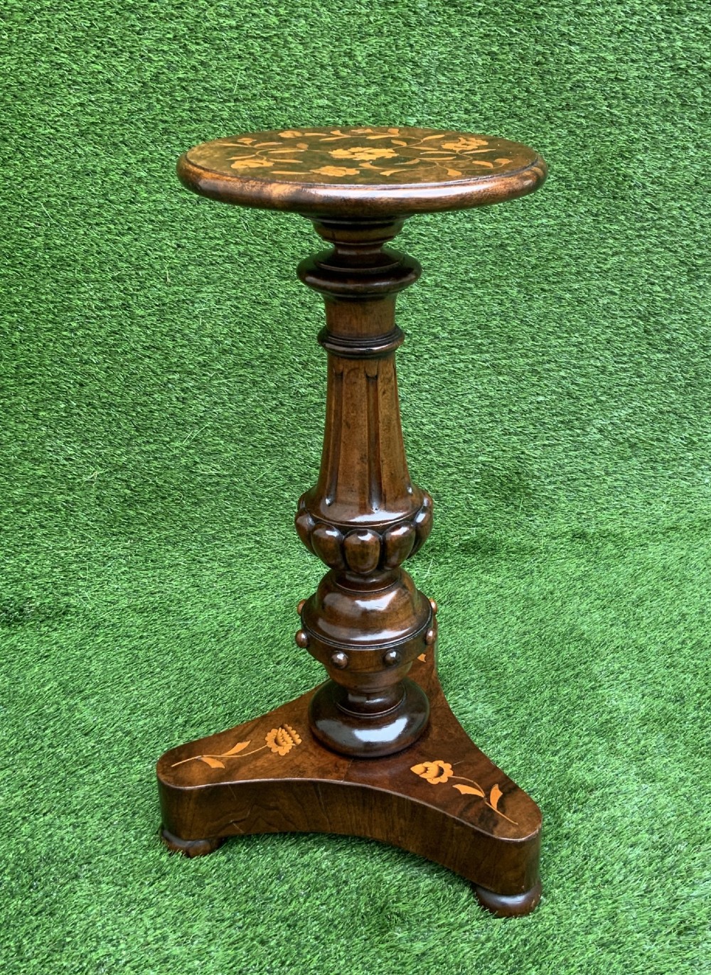 A 19th-century Dutch marquetry wine table featuring a circular floral-inlaid top, a carved central column, and a shaped triform base raised on bun feet. View II