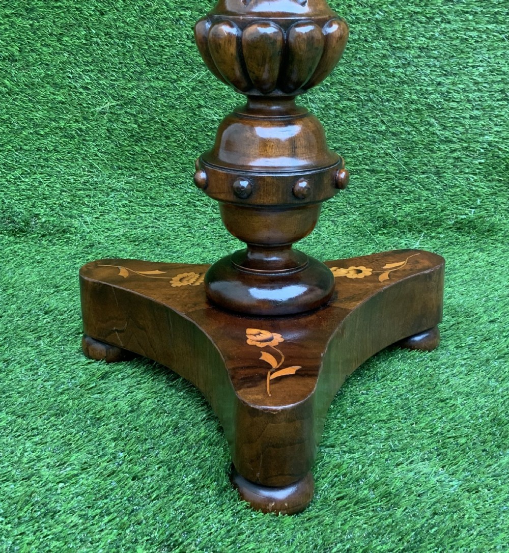 A 19th-century Dutch marquetry wine table featuring a circular floral-inlaid top, a carved central column, and a shaped triform base raised on bun feet. View VII