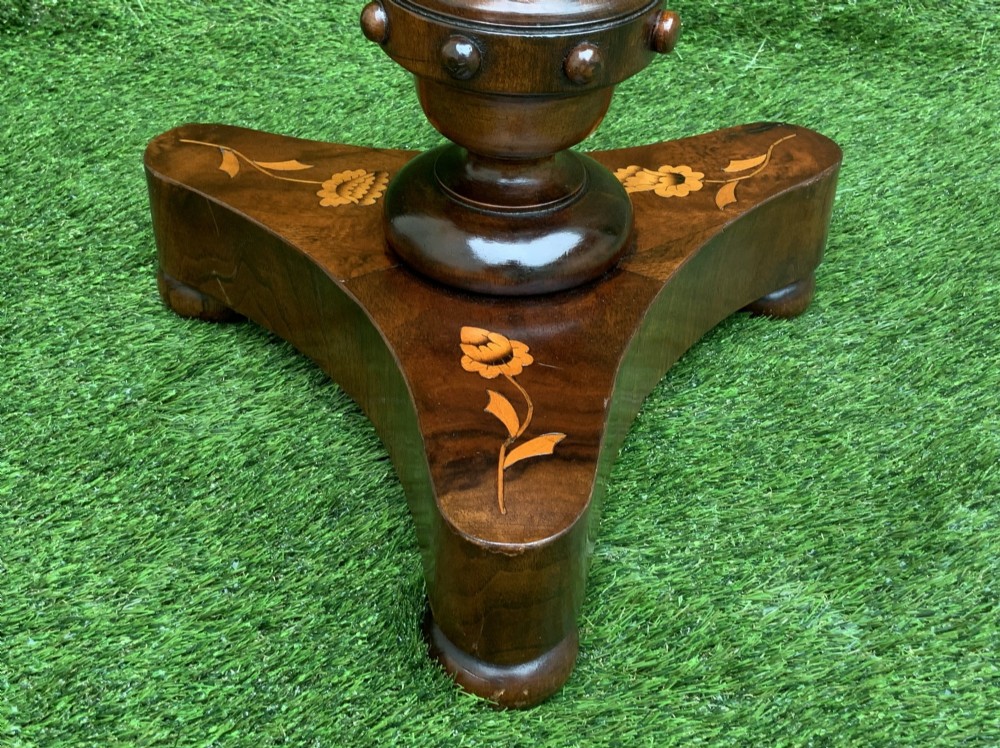 A 19th-century Dutch marquetry wine table featuring a circular floral-inlaid top, a carved central column, and a shaped triform base raised on bun feet. View VIII