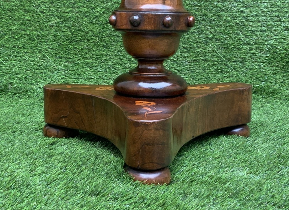 A 19th-century Dutch marquetry wine table featuring a circular floral-inlaid top, a carved central column, and a shaped triform base raised on bun feet. View X