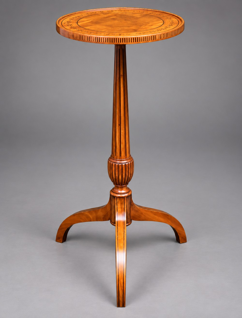 A 19th-century satinwood wine table featuring a circular top with inlaid marquetry detailing, supported by a fluted central pedestal and three downswept tripod legs.